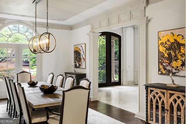 816 Blackfoot Trl, Suwanee, GA 30024 - dining area featuring a chandelier, decorative columns, arched walkways, and light wood-style flooring
