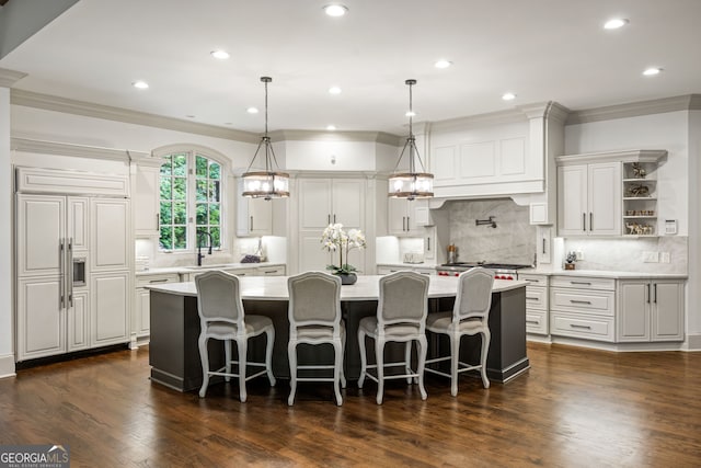 816 Blackfoot Trl, Suwanee, GA 30024 - kitchen featuring light countertops, ornamental molding, a sink, a center island with sink, and backsplash