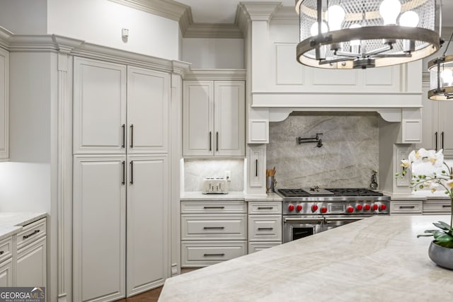 816 Blackfoot Trl, Suwanee, GA 30024 - kitchen with double oven range, a chandelier, tasteful backsplash, crown molding, and decorative light fixtures