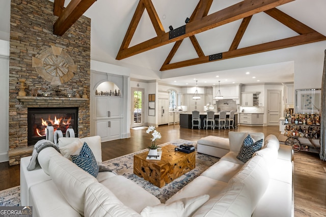 816 Blackfoot Trl, Suwanee, GA 30024 - living area with high vaulted ceiling, beamed ceiling, wood finished floors, and a stone fireplace