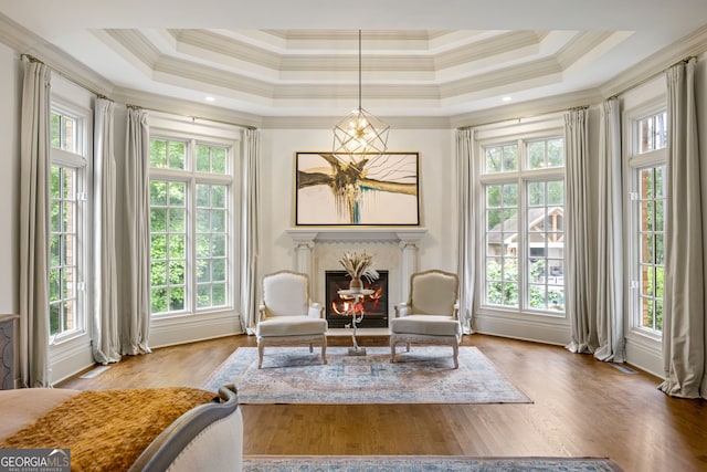 816 Blackfoot Trl, Suwanee, GA 30024 - sitting room with healthy amount of natural light, ornamental molding, a glass covered fireplace, wood finished floors, and a raised ceiling