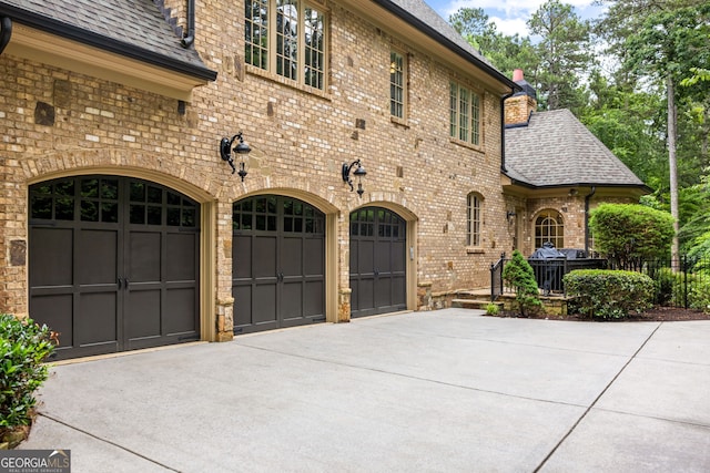 816 Blackfoot Trl, Suwanee, GA 30024 - view of front of home with concrete driveway, a garage, brick siding, and a shingled roof