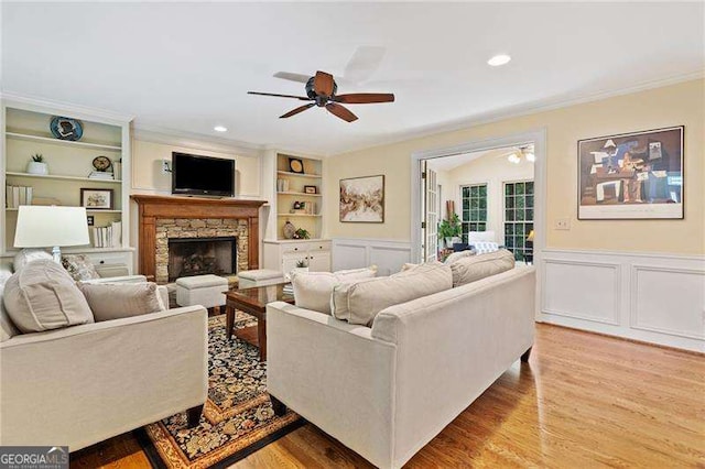 4402 Windsor Oaks Chase, Marietta, GA 30066 - living room featuring ceiling fan, built in shelves, crown molding, a decorative wall, and wood finished floors