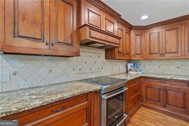 4402 Windsor Oaks Chase, Marietta, GA 30066 - kitchen featuring stainless steel range with electric stovetop, brown cabinets, light stone counters, tasteful backsplash, and recessed lighting