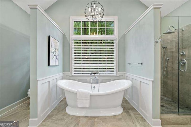 4402 Windsor Oaks Chase, Marietta, GA 30066 - bathroom with a chandelier, a stall shower, a freestanding bath, toilet, and a decorative wall
