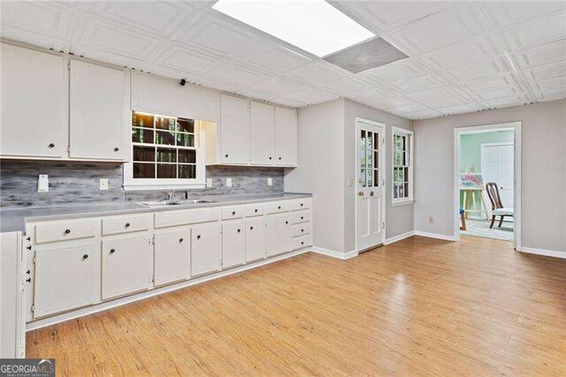4402 Windsor Oaks Chase, Marietta, GA 30066 - kitchen with light wood-style floors, white cabinets, decorative backsplash, and an ornate ceiling
