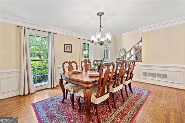 4402 Windsor Oaks Chase, Marietta, GA 30066 - dining space with a chandelier, plenty of natural light, a wainscoted wall, light wood-style flooring, and a decorative wall
