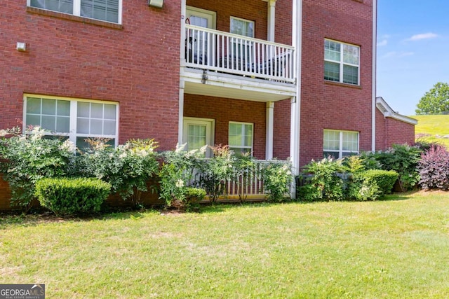 7712 Autry Cir Unit 701, Douglasville, GA 30134 - view of side of home featuring a lawn, brick siding, and a balcony