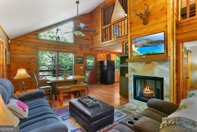 488 S Lemmon Ln Unit 289, Ellijay, GA 30540 - living area featuring wooden walls, ceiling fan, light wood-type flooring, high vaulted ceiling, and a fireplace