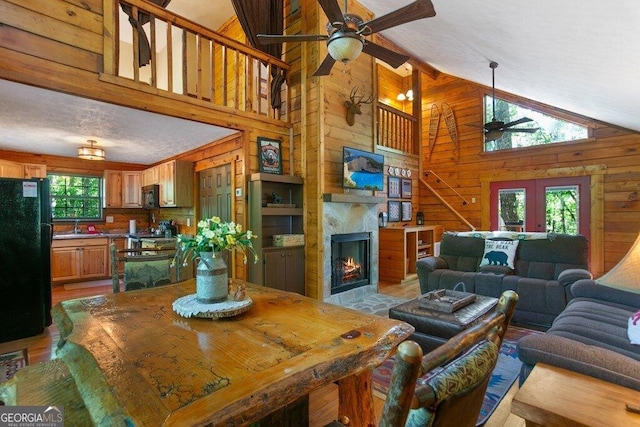 488 S Lemmon Ln Unit 289, Ellijay, GA 30540 - living area featuring a ceiling fan, wooden walls, light wood-style floors, high vaulted ceiling, and a large fireplace
