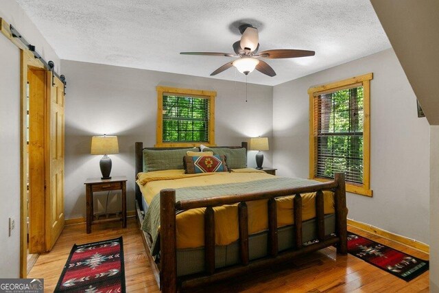 488 S Lemmon Ln Unit 289, Ellijay, GA 30540 - bedroom featuring a textured ceiling, light wood-style floors, a barn door, and ceiling fan