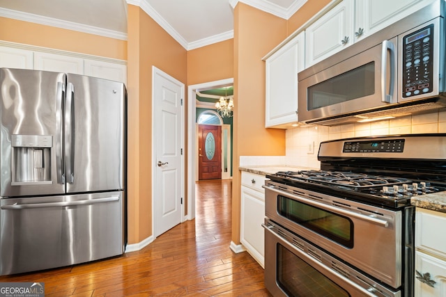 120 Bent Creek Dr, Woodstock, GA 30189 - kitchen with appliances with stainless steel finishes, ornamental molding, a chandelier, hardwood / wood-style flooring, and white cabinets