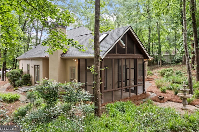 120 Bent Creek Dr, Woodstock, GA 30189 - view of front of home featuring a sunroom, a shingled roof, stucco siding, and a chimney
