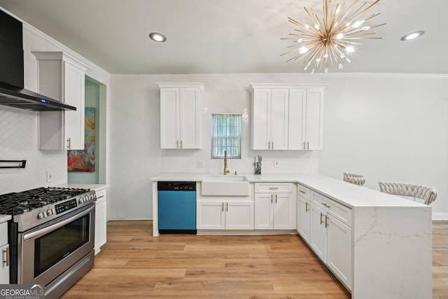 999 Smith St SW, Atlanta, GA 30310 - kitchen with dishwashing machine, stainless steel range with gas stovetop, wall chimney exhaust hood, a peninsula, and a chandelier