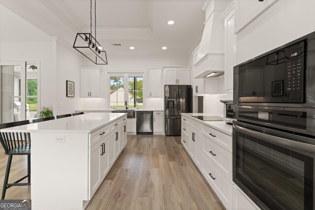 31 Bitter End Ct, Waverly, GA 31565 - kitchen featuring stainless steel appliances, crown molding, light countertops, white cabinets, and a raised ceiling