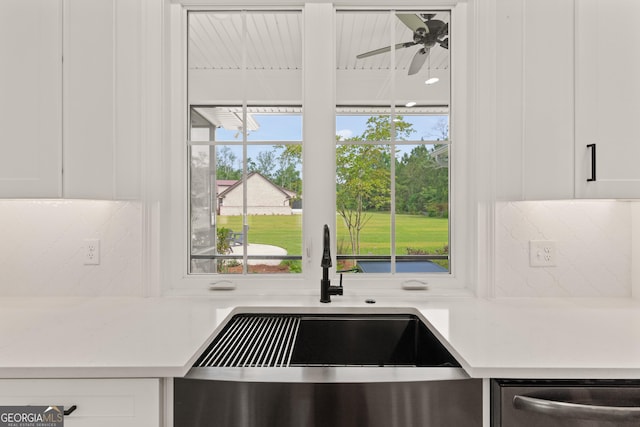 31 Bitter End Ct, Waverly, GA 31565 - kitchen with dishwasher, a sink, white cabinets, and decorative backsplash