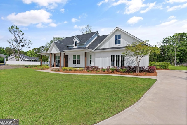 31 Bitter End Ct, Waverly, GA 31565 - modern farmhouse style home featuring a front yard, board and batten siding, a shingled roof, and concrete driveway