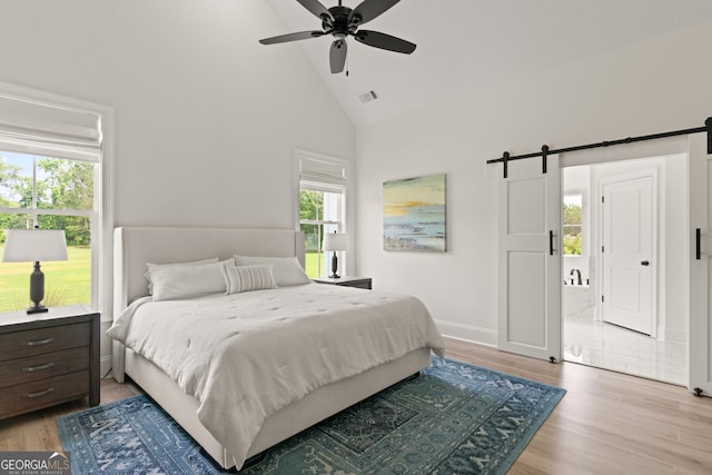 31 Bitter End Ct, Waverly, GA 31565 - bedroom featuring high vaulted ceiling, a barn door, light wood-style floors, baseboards, and ceiling fan