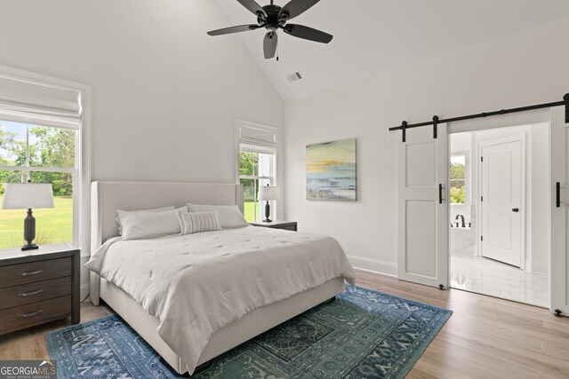 31 Bitter End Ct, Waverly, GA 31565 - bedroom featuring high vaulted ceiling, a barn door, light wood-style flooring, and ceiling fan