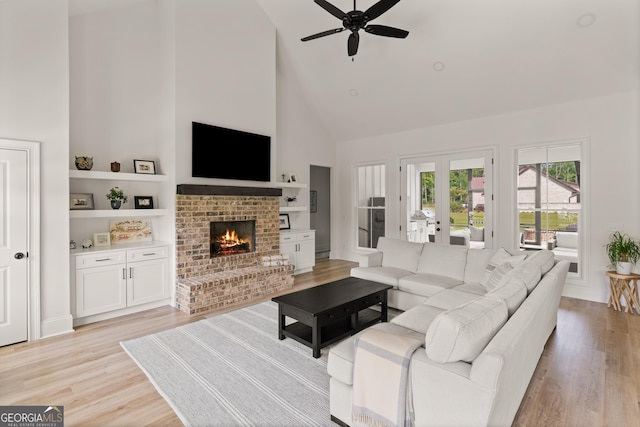 31 Bitter End Ct, Waverly, GA 31565 - living room with high vaulted ceiling, a ceiling fan, light wood-type flooring, a fireplace, and french doors