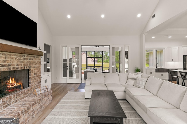 31 Bitter End Ct, Waverly, GA 31565 - living area featuring high vaulted ceiling, a brick fireplace, light wood-style flooring, and recessed lighting