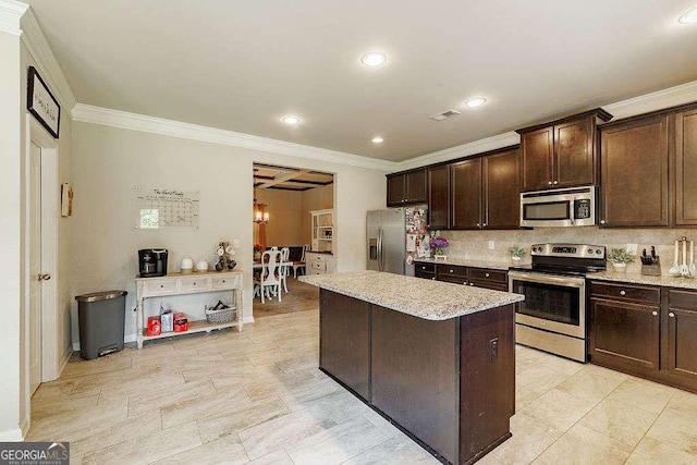 1148 Abe Lincoln Way, Jefferson, GA 30549 - kitchen featuring stainless steel appliances, crown molding, dark brown cabinets, tasteful backsplash, and a center island