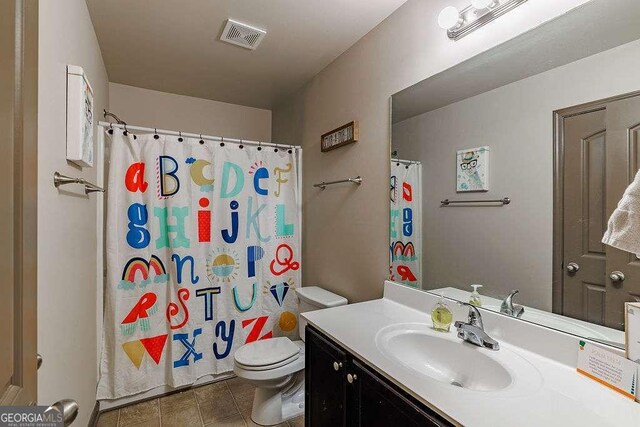 1148 Abe Lincoln Way, Jefferson, GA 30549 - bathroom featuring toilet, vanity, tile patterned floors, and a shower with shower curtain