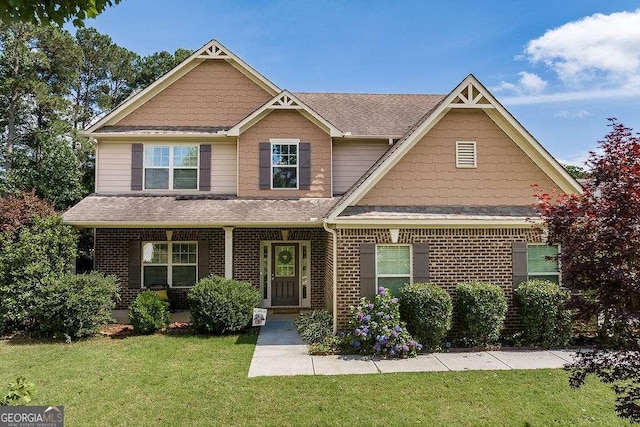 1148 Abe Lincoln Way, Jefferson, GA 30549 - view of front facade featuring a front yard, brick siding, a porch, and roof with shingles
