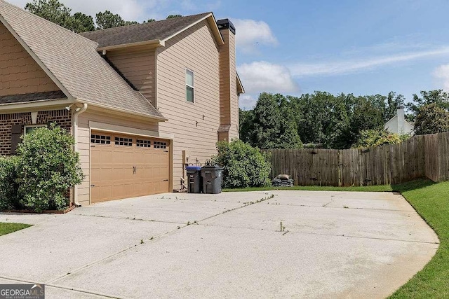 1148 Abe Lincoln Way, Jefferson, GA 30549 - view of side of property featuring concrete driveway, a chimney, and roof with shingles