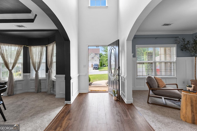 3 Stonebridge Way, Newnan, GA 30265 - foyer with ornamental molding, a decorative wall, a wainscoted wall, arched walkways, and dark wood-style flooring
