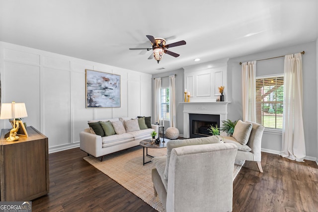 3 Stonebridge Way, Newnan, GA 30265 - living area featuring a fireplace, a ceiling fan, dark wood-type flooring, a decorative wall, and baseboards