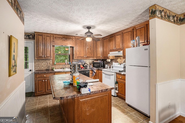 198 Hickory Ave, Demorest, GA 30535 - kitchen with black appliances, under cabinet range hood, brown cabinetry, ceiling fan, and wainscoting