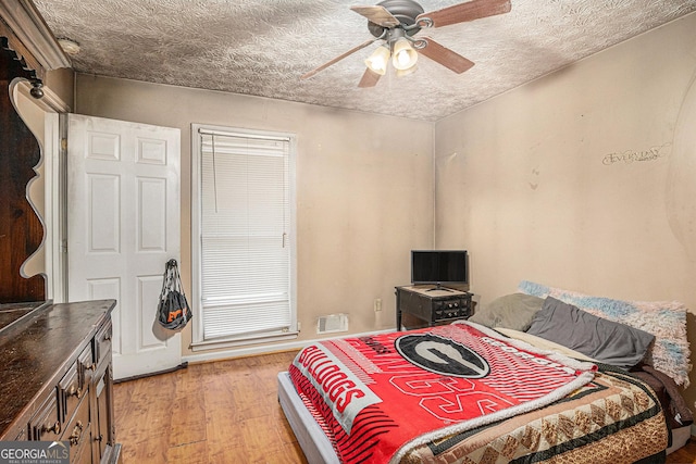 198 Hickory Ave, Demorest, GA 30535 - bedroom featuring light wood finished floors, a ceiling fan, and a textured ceiling