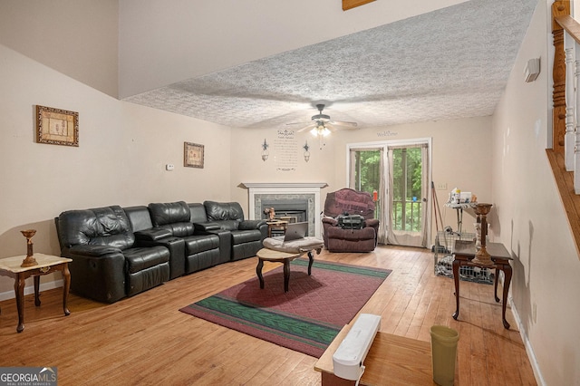 198 Hickory Ave, Demorest, GA 30535 - living room with a ceiling fan, a fireplace, hardwood / wood-style flooring, a textured ceiling, and baseboards