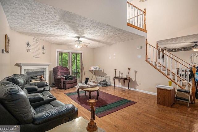 198 Hickory Ave, Demorest, GA 30535 - living room featuring a ceiling fan, wood finished floors, stairs, a textured ceiling, and a high end fireplace