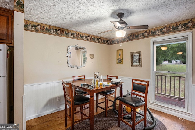 198 Hickory Ave, Demorest, GA 30535 - dining space featuring light wood-style flooring, a wainscoted wall, ceiling fan, and a textured ceiling