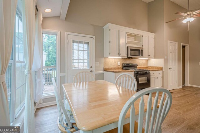 1137 Poplar Log Pl, Austell, GA 30168 - dining space with light wood-style floors, ceiling fan, baseboards, and vaulted ceiling