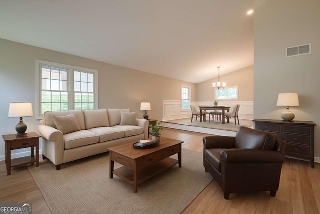 1137 Poplar Log Pl, Austell, GA 30168 - living room with a chandelier, light wood-style flooring, lofted ceiling, and baseboards