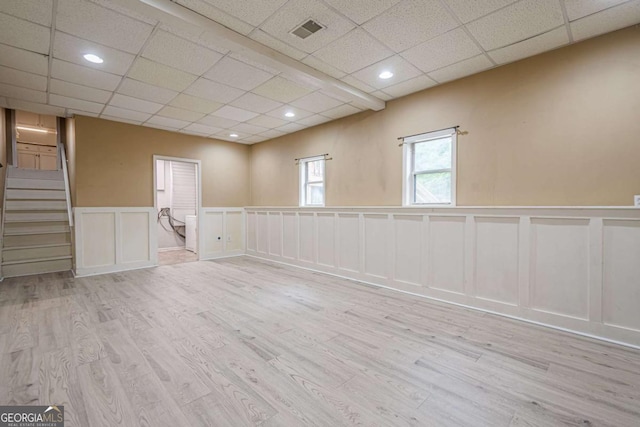 1137 Poplar Log Pl, Austell, GA 30168 - spare room featuring a decorative wall, wood finished floors, a drop ceiling, a wainscoted wall, and stairs