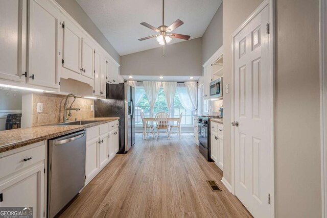 1137 Poplar Log Pl, Austell, GA 30168 - kitchen featuring stainless steel appliances, a sink, a ceiling fan, lofted ceiling, and light wood-type flooring