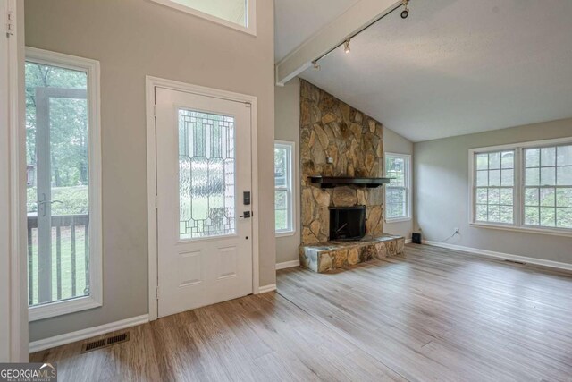 1137 Poplar Log Pl, Austell, GA 30168 - entryway with rail lighting, wood finished floors, a stone fireplace, baseboards, and high vaulted ceiling