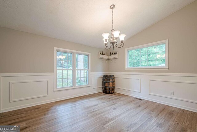 1137 Poplar Log Pl, Austell, GA 30168 - empty room featuring a chandelier, wood finished floors, plenty of natural light, wainscoting, and a decorative wall