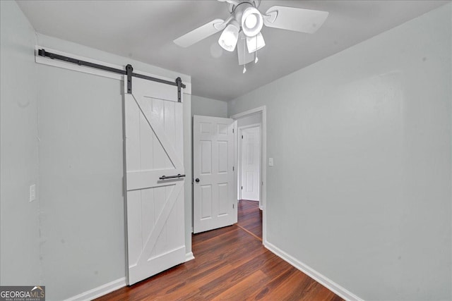 413 Panorama Pl, Macon, GA 31220 - unfurnished bedroom with a barn door, dark wood-style flooring, and a ceiling fan
