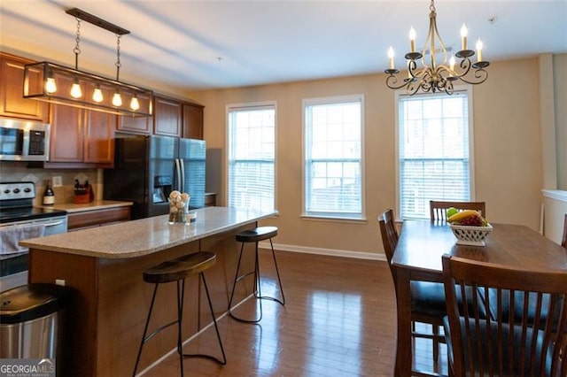 6089 Indian Wood, Mableton, GA 30126 - kitchen featuring appliances with stainless steel finishes, dark wood-style flooring, a kitchen island, a chandelier, and baseboards