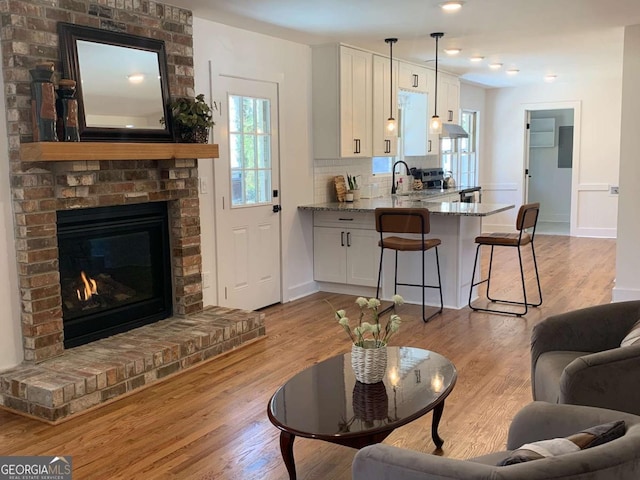 442 Mountain Park Trl, Stone Mountain, GA 30087 - living room with a brick fireplace, light wood finished floors, and baseboards