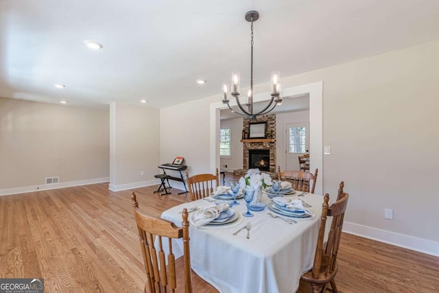 442 Mountain Park Trl, Stone Mountain, GA 30087 - dining room featuring light wood finished floors, a fireplace, a chandelier, baseboards, and recessed lighting