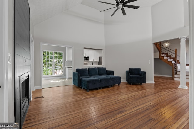 1133 Stone Brook Ln, Bremen, GA 30110 - living area featuring ceiling fan, high vaulted ceiling, a fireplace, stairs, and wood finished floors