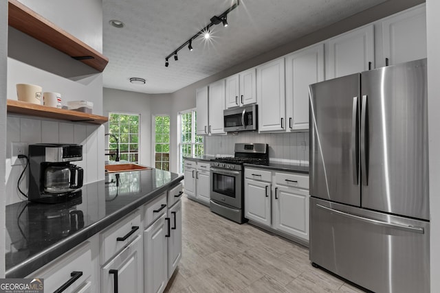 1133 Stone Brook Ln, Bremen, GA 30110 - kitchen featuring stainless steel appliances, white cabinets, a sink, open shelves, and decorative backsplash