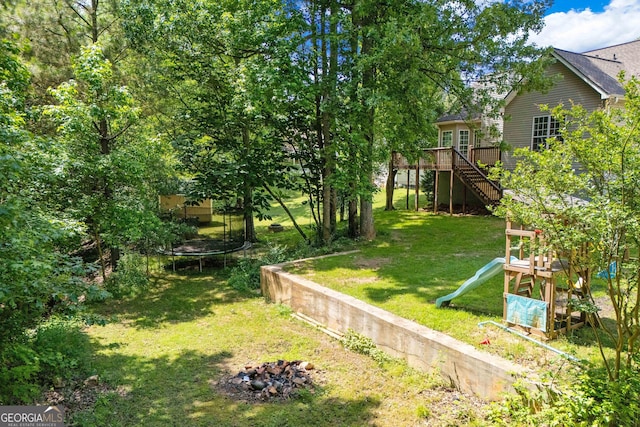 1133 Stone Brook Ln, Bremen, GA 30110 - view of green lawn with a trampoline, a playground, a deck, and stairs