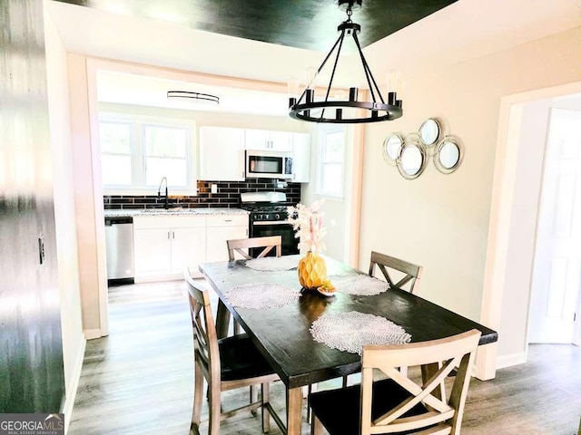 2190 Gordon Cir SE, Smyrna, GA 30080 - dining space with light wood finished floors, a chandelier, and healthy amount of natural light
